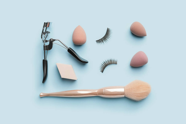 Make-up-Schwämme mit Pinsel und Wimpernzange auf farbigem Hintergrund - Foto, Bild