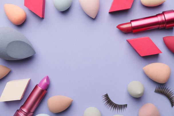 Cadre en éponges de maquillage et rouge à lèvres sur fond de couleur - Photo, image