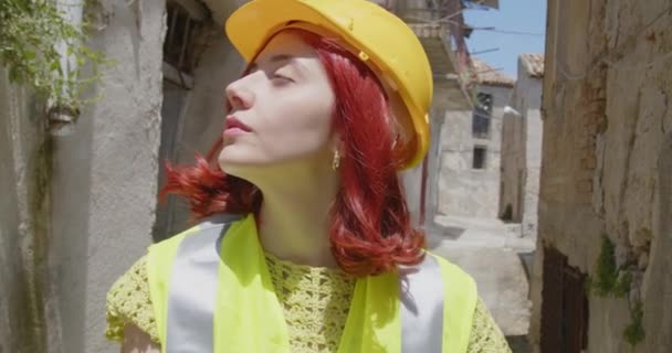 Outdoor footage of beauty Italian architect in yellow helmet. Young woman in construction side at daytime  - Záběry, video