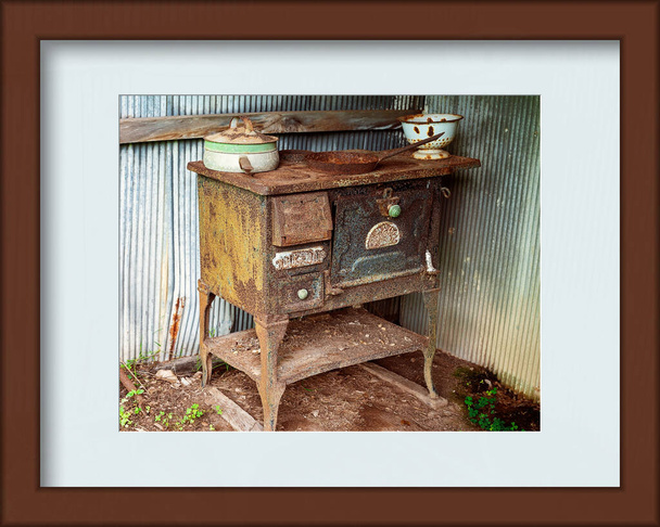 Старая ржавая железная печь прошлых лет, оставленная снаружи, чтобы разъедаться дальше, представлена в фоторамке - Фото, изображение