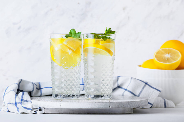 Hafif arka planda lezzetli soğuk limonata bardakları - Fotoğraf, Görsel