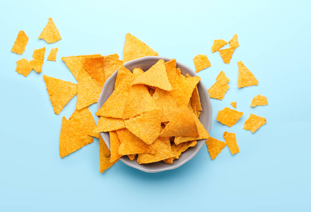 Schaal met lekkere nacho 's op kleur achtergrond - Foto, afbeelding