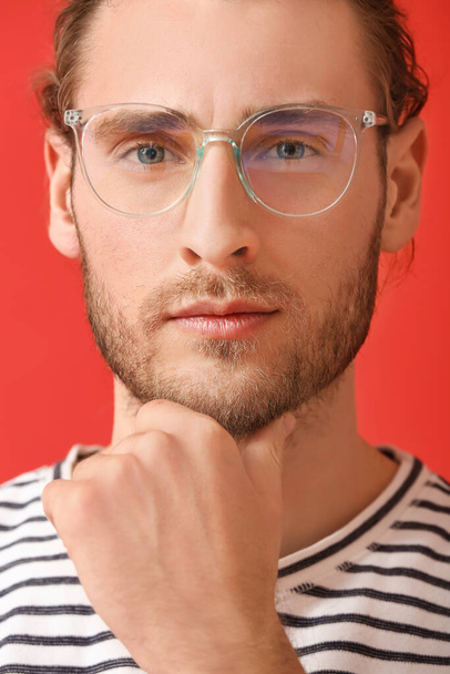 Young man wearing eyeglasses on color background - Fotó, kép
