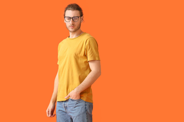 Fiatal férfi visel szemüveget színes háttér - Fotó, kép