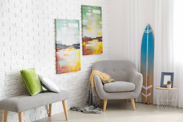 Odanın içinde koltuk olan sörf tahtası. - Fotoğraf, Görsel