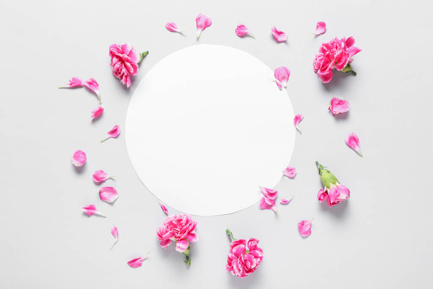 Hermosas flores de clavel y tarjeta en blanco sobre fondo claro - Foto, Imagen