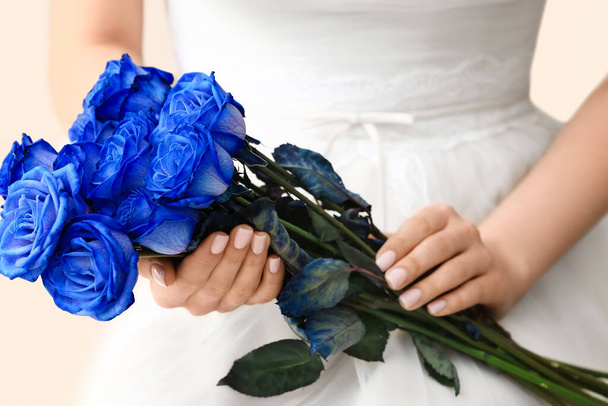 Hermosa novia con rosas azules sobre fondo claro, primer plano - Foto, Imagen
