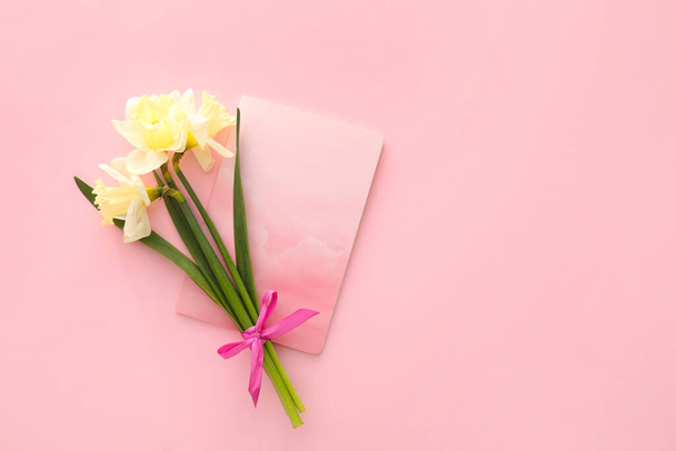 Gyönyörű nárcisz és notebook színes háttér - Fotó, kép