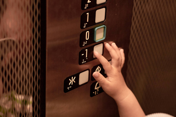 Дитині цікаво і натискає кнопку ліфта. Концепція ураження мікробів та незахищеності
 - Фото, зображення