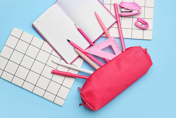 Pencil case and stationery on color background - Фото, зображення