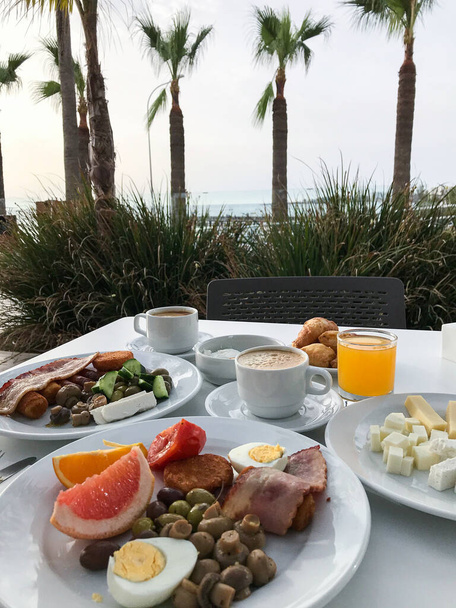 desayuno con huevos revueltos con tocino y café en la terraza del hotel a orillas del mar. Protaras. Ayia Napa. Chipre - Foto, imagen