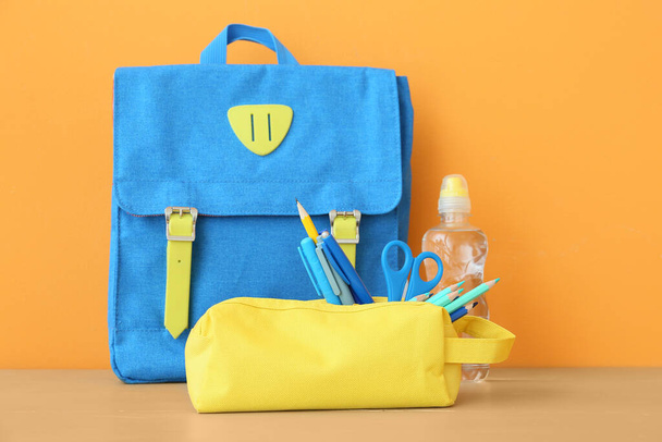 Шафа з олівцем з канцелярським приладдям та рюкзаком на кольоровому фоні
 - Фото, зображення
