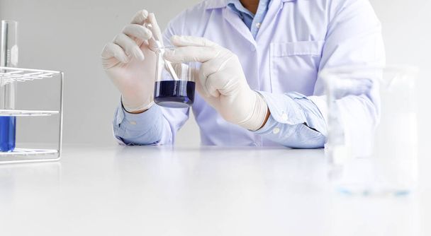 Nauka innowacyjny mężczyzna medyczny lub naukowy laboratoryjny badacz wykonuje testy z płynem w laboratorium. sprzęt nauka eksperymenty technologia Coronavirus Covid-19 szczepionka badania - Zdjęcie, obraz