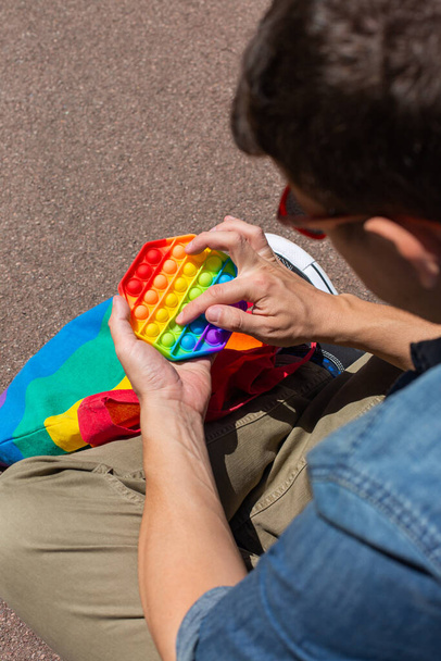 虹を持つ男はそれをおもちゃ、 lgbtバッグ、プライド月をポップ - 写真・画像