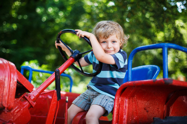 Petit garçon drôle de trois ans jouant sur tracteur
 - Photo, image