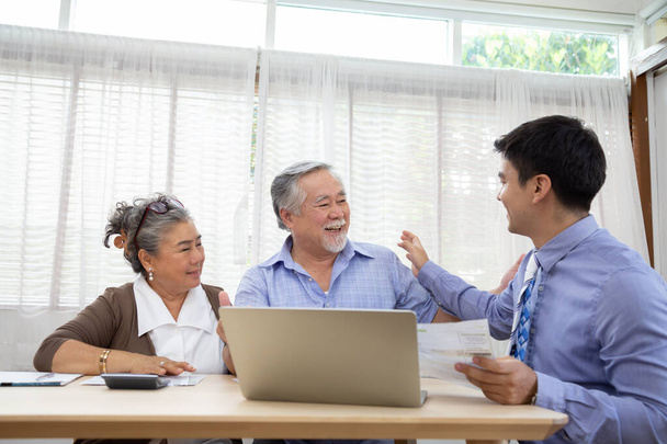 Szczęśliwa para seniorów podczas spotkania z agentem lub doradcą finansowym, południowo-wschodnioazjatyckim modelem starszym - Zdjęcie, obraz