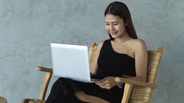 若いです美しい女性労働者作業ノートパソコンで彼女の膝の上にリラックスしながら座ってカフェ - 写真・画像