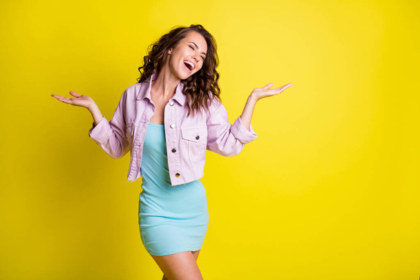 Photo of charming cheerful lady closed eyes raise arms palms open mouth smile isolated on yellow color background - Fotó, kép