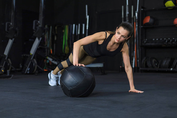 Fit and muscular woman exercising with medicine ball at gym. - Fotoğraf, Görsel