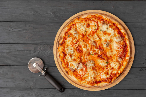 Tasty pizza on black wooden background top view - Фото, зображення