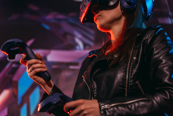 Virtual reality. A woman plays games in a virtual reality helmet. - Photo, Image