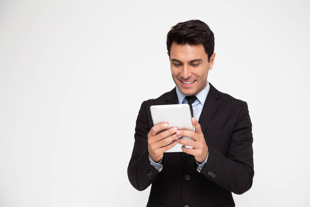 Felice giovane uomo d'affari in giacca e cravatta utilizzando tablet digitale isolato su sfondo bianco - Foto, immagini