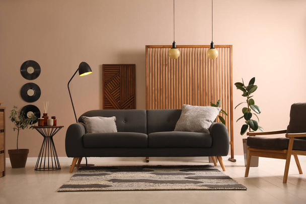 Stylish living room interior with comfortable dark sofa - 写真・画像