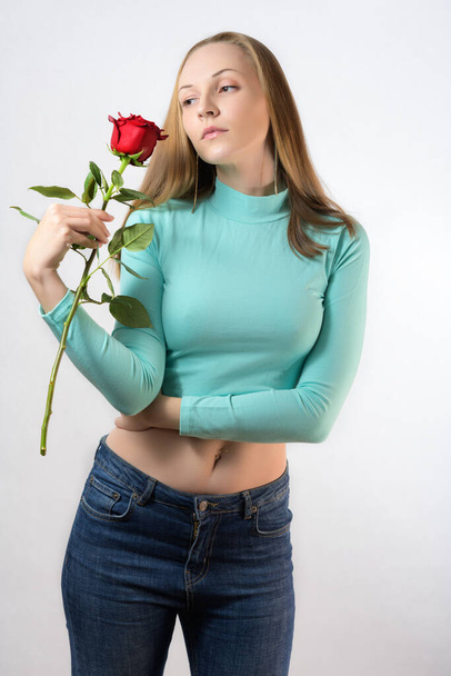 Frau hält eine rote Rose in der Hand auf hellem Hintergrund. - Foto, Bild