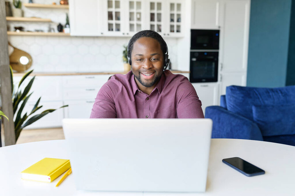 Happy African-American man with locks hair wearing wireless headset - Photo, Image