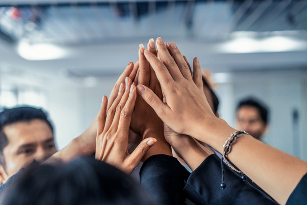 Muchos empresarios felices levantan las manos juntos. - Foto, imagen