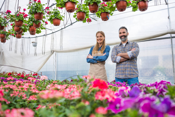 Happy couple is owning small business greenhouse store.  - Photo, image