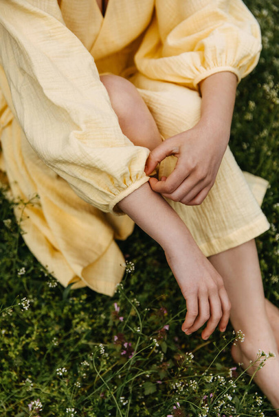 Closeup of female hand adjusting sleeve on her summer dress, outdoors. - Фото, изображение