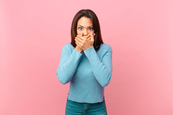 young hispanic woman covering mouth with hands with a shocked - Фото, изображение