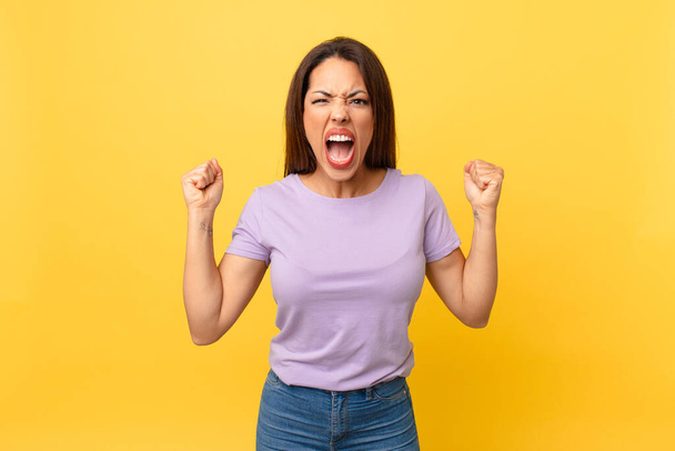 young hispanic woman shouting aggressively with an angry expression - Photo, image
