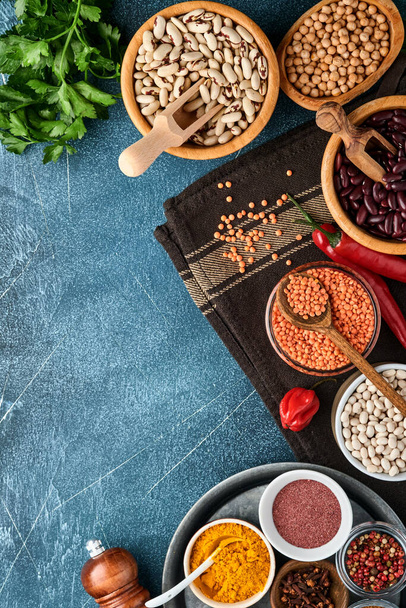 Legumes, lentils, chickpea, beans assortment, tasty appetizing ingredients spices grocery for cooking healthy kitchen on black table. Weight loss diet and fight against cholesterol concept. Top view. - Foto, Imagem