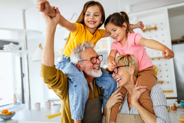Happy grandparents having fun times with beautiful children at home - Foto, Imagen