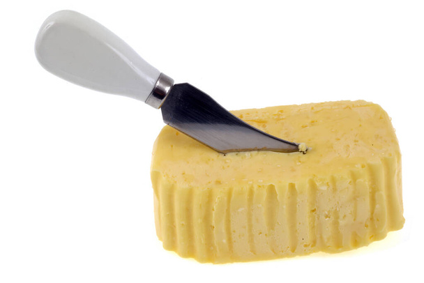 Boter met een mes erin vastgeplakt close-up op witte achtergrond - Foto, afbeelding