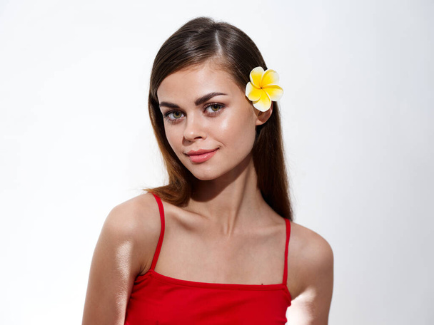 pretty woman in red t-shirt with yellow flower in her hair - Zdjęcie, obraz