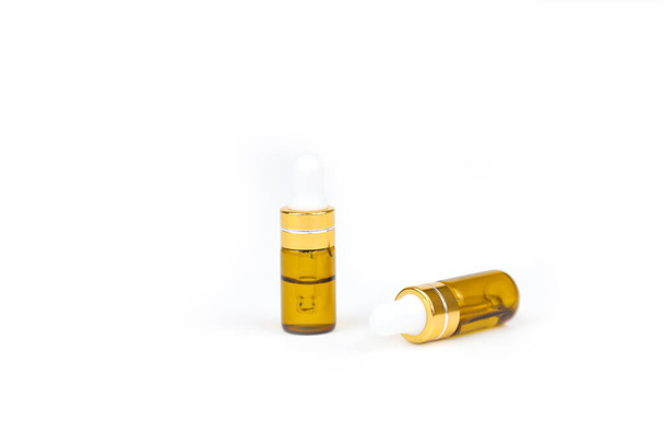Two gold bottles of hyaluronic acid with pipette isolated on white background. Essential oil for skin care. Mockup, front view. - Fotó, kép
