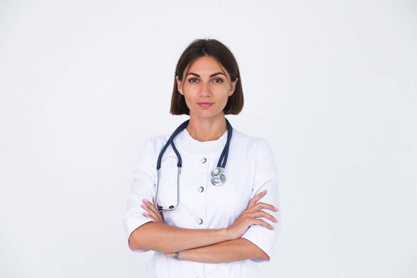 Женщина-врач в халате на белом фоне изолированная, уверенная в себе улыбка - Фото, изображение
