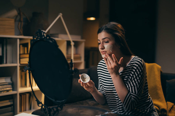 woman applying cosmetic face mask at home - Valokuva, kuva