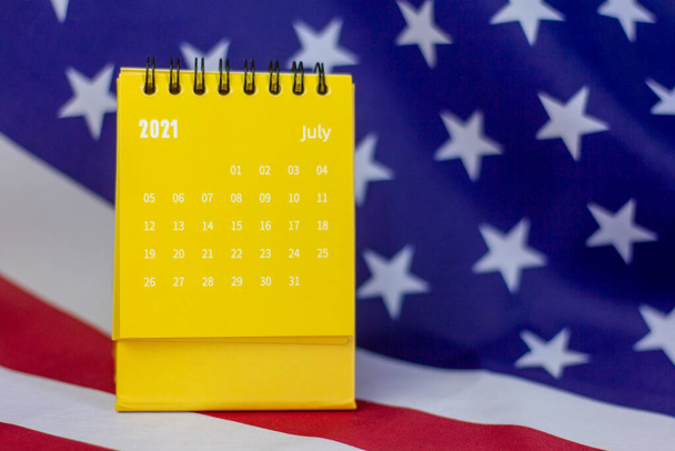Capovolgere il calendario per luglio 2021. Un calendario desktop per pianificare, assegnare, organizzare e gestire ogni data sullo sfondo della bandiera americana - Foto, immagini