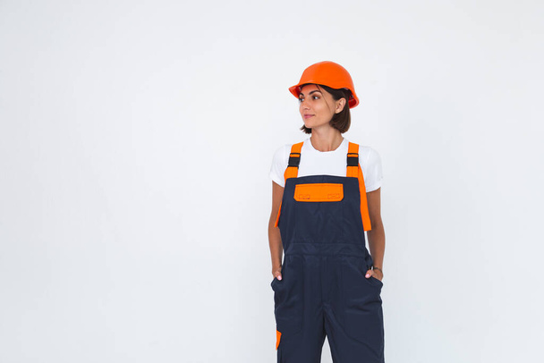 Pretty woman engineer in building protective helmet on white background confident smile crossed arms - Valokuva, kuva