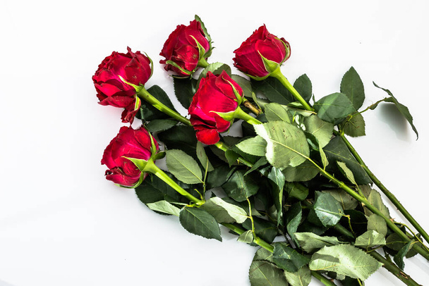 Flowers background with bouquet of red roses on white background useful as valentine card, greeting card, wedding invitation or anniversary card. - Foto, imagen