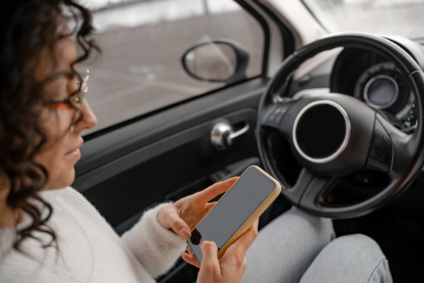 European girl use mobile phone in automobile - Photo, Image