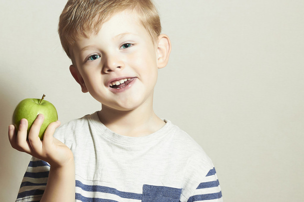 Vtipné dítě jíst jablka.Malý pohledný chlapec se zeleným jablkem. Zdravé jídlo. Ovoce. Užijte si jídlo - Fotografie, Obrázek