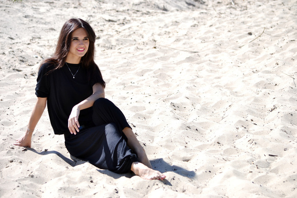 Дівчина сидить на піску
 - Фото, зображення