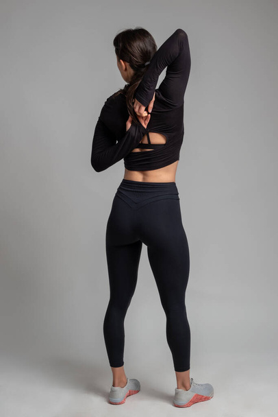 Flexible girl doing stretching workout on grey background - Fotoğraf, Görsel