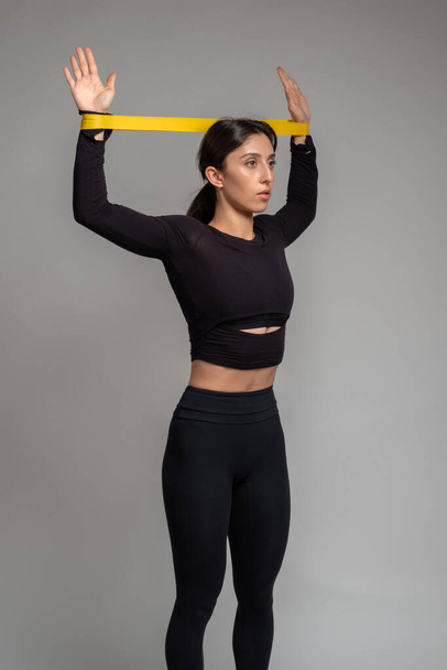 Girl doing exercises with resistance band loop in studio - Photo, image