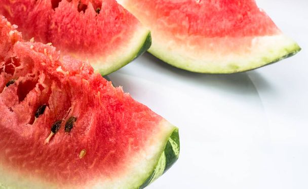 Slices of watermelon isolated on white background. Summer fruit close-up. - 写真・画像